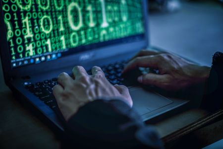 Hacker stealing password and identity, computer crime.