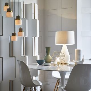 room with white dinner set and hanging lights
