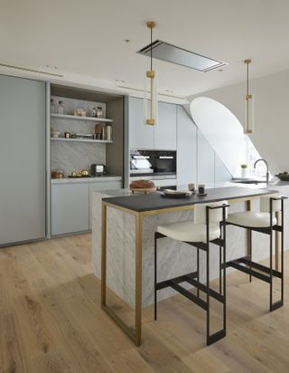 A kitchen with an island that extends into a breakfast bar