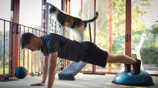 Man exercising with cat on his back