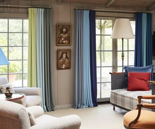 open plan living space with armchairs and multicolored curtains