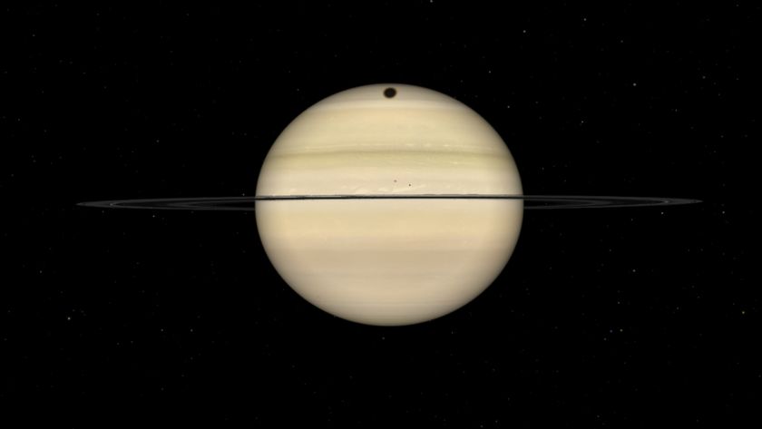 A simulation of Saturn showing its rings aligned almost edge on to Earth against a black background, with a circular dark shadow marking its upper disk.