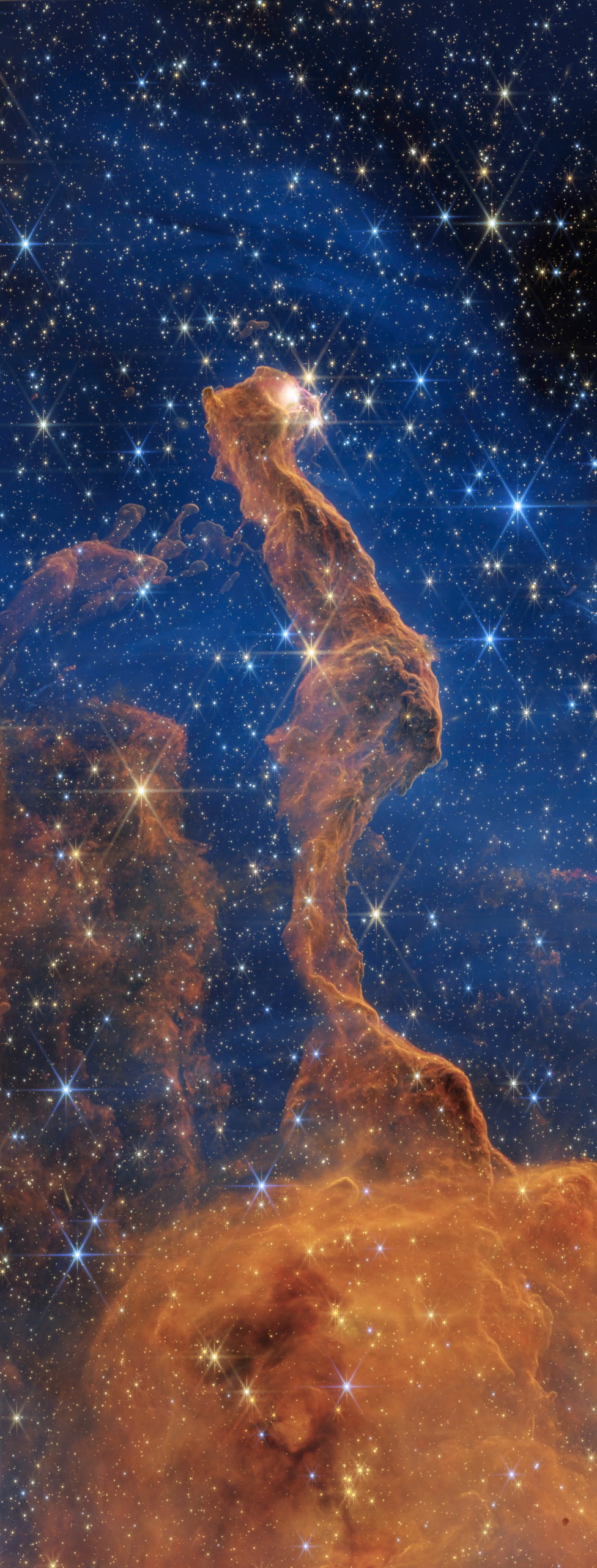 NASA&amp;rsquo;s James Webb Space Telescope&amp;rsquo;s near-infrared view reveals detailed structures in the pillar and many stars, as well as some background galaxies. The glowing yellow eye may be a young star embedded in dust.