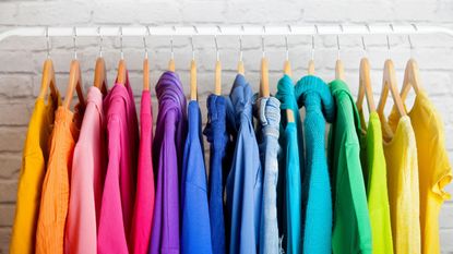 Rainbow clothing lined up on a rack