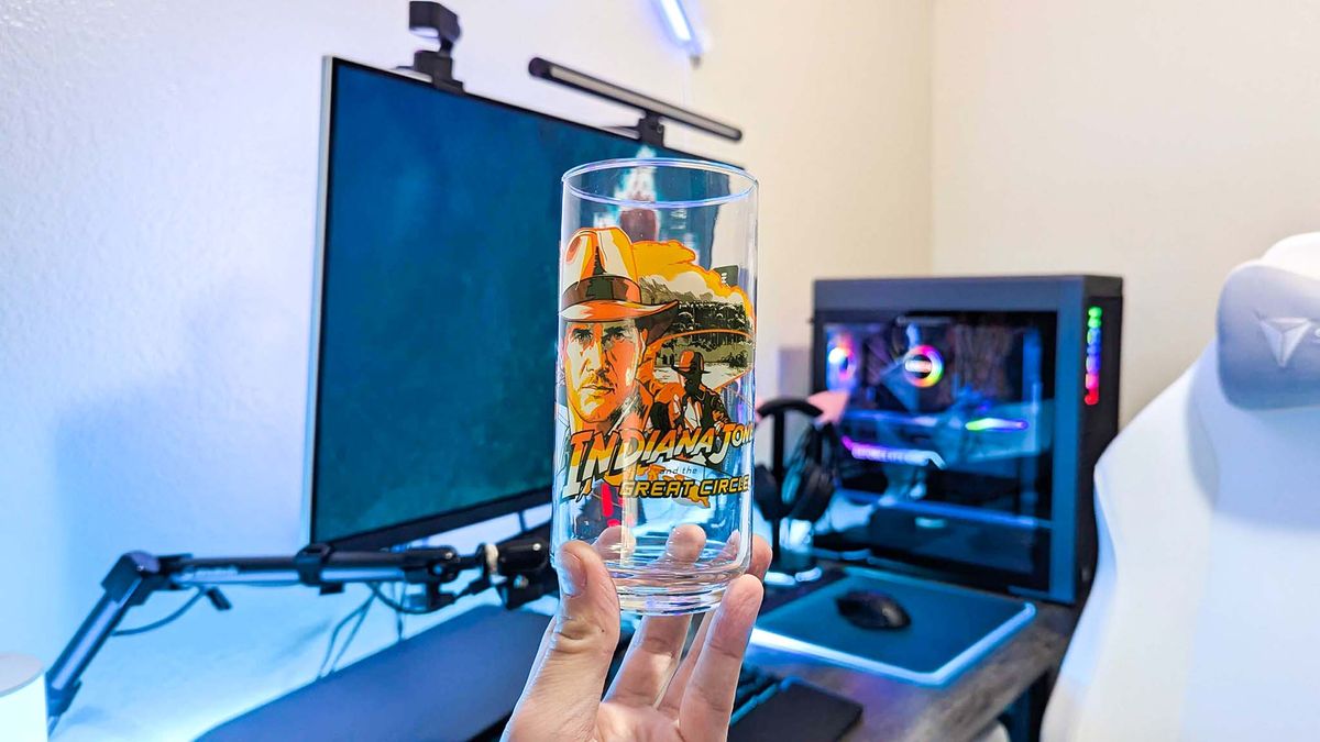 An Xbox x IHOP collectible glass held in a hand, featuring unique art from Indiana Jones and the Great Circle.