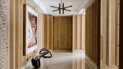 a wooden paneled entryway with terrazzo floor