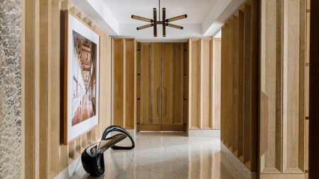 a wooden paneled entryway with terrazzo floor