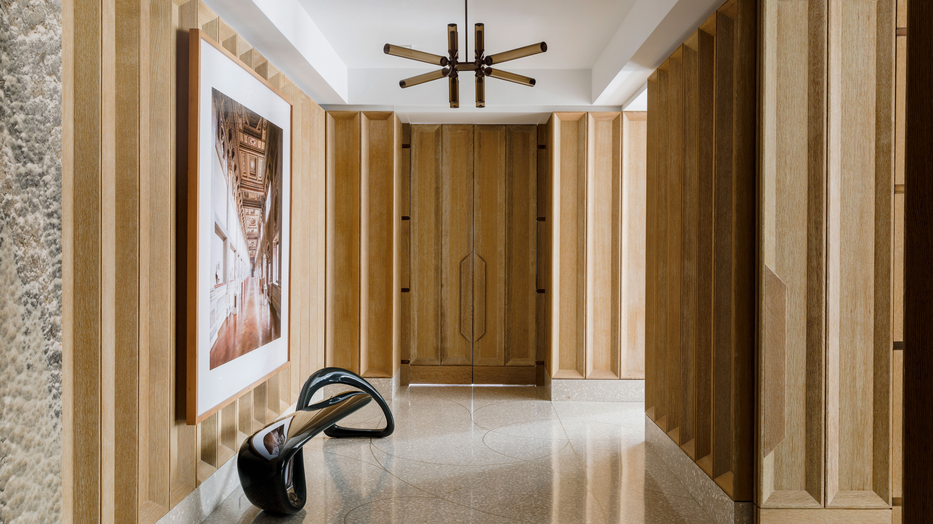 a wooden paneled entryway with terrazzo floor