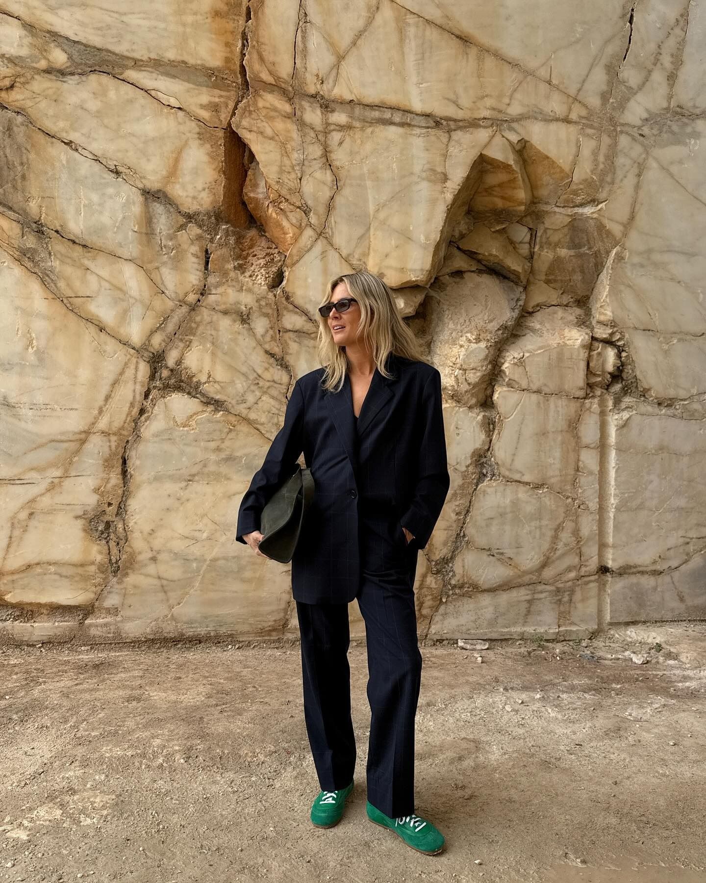 Lucy Williams wearing a suit with green COS sneakers.