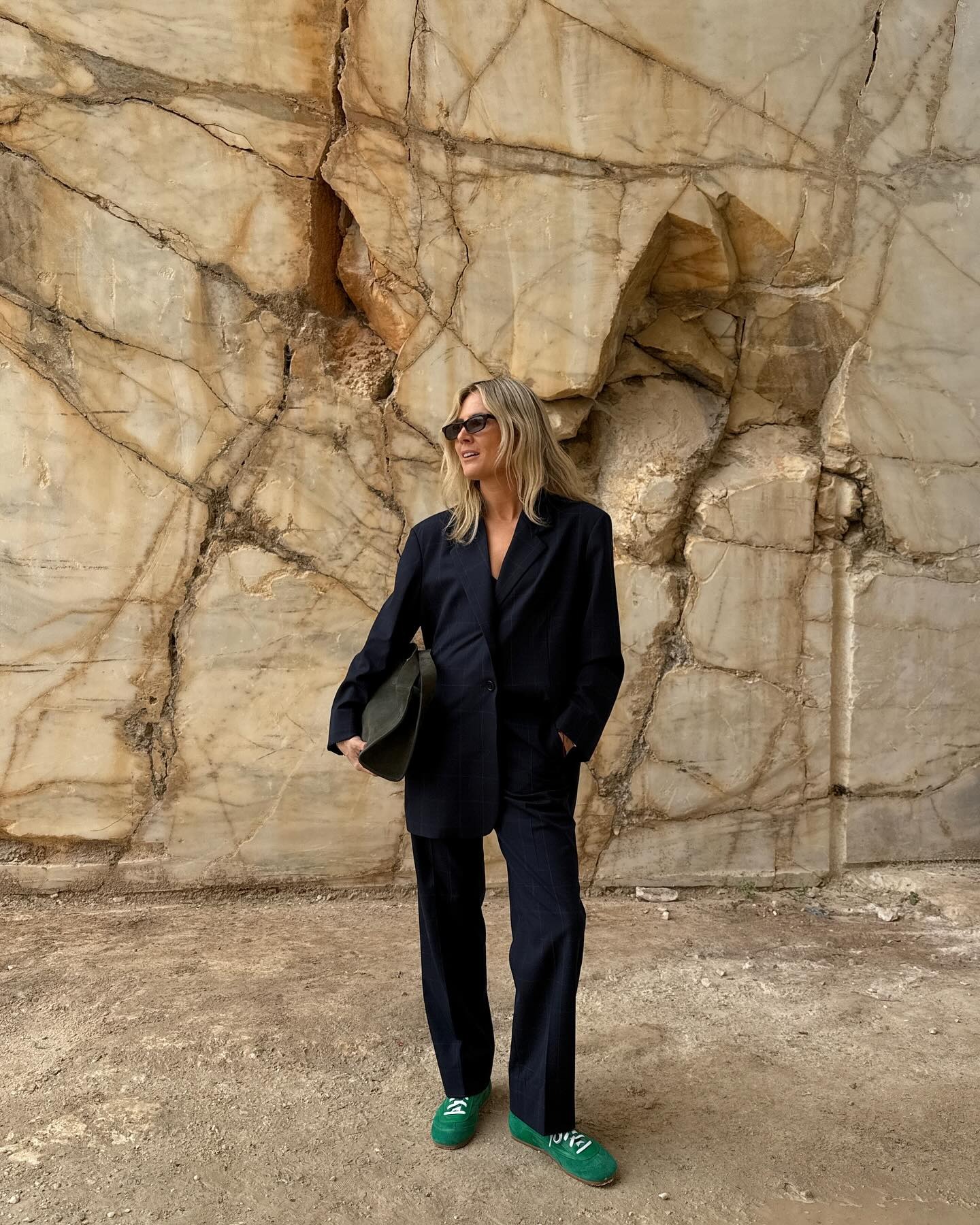 Lucy Williams wearing a suit with green COS sneakers.