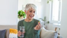 Woman taking a menopause supplement with water