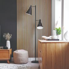 A black-painted living room with a part of one wall covered in vertical slim slats