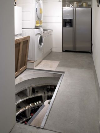 Utility room idea with built in, underfloor wine cellar by Spiral Cellars