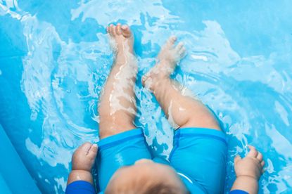 A Southeast Asian baby boy relaxing in a inflatable pool 