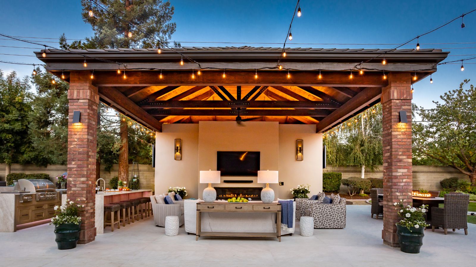 Outdoor hosting space with kitchen area, covered lounge and dining table