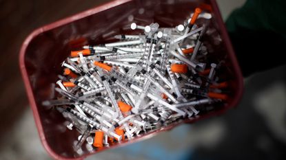 A bucket of needles is seen outside a health clinic in Portland, Maine.