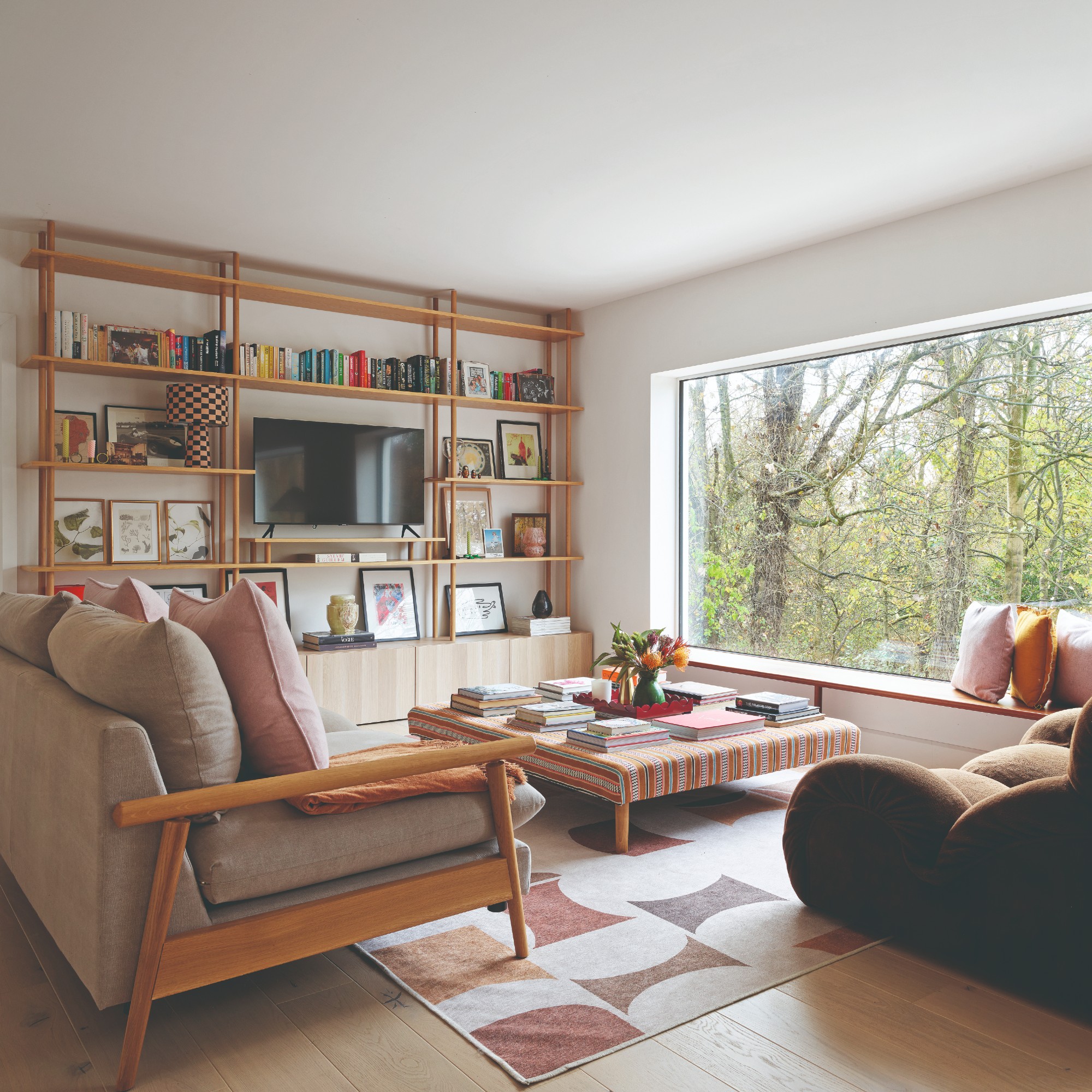 A living room with a TV placed on a bookshelf surrounded by decor