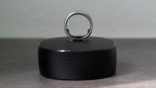 The RingConn Gen 2 Smart Ring balanced on its charging case