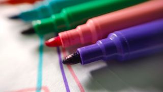 A bunch of permanent markers laying on a table