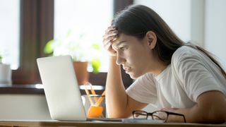 How to prepare for a recession; a woman looks at a computer screen in despair