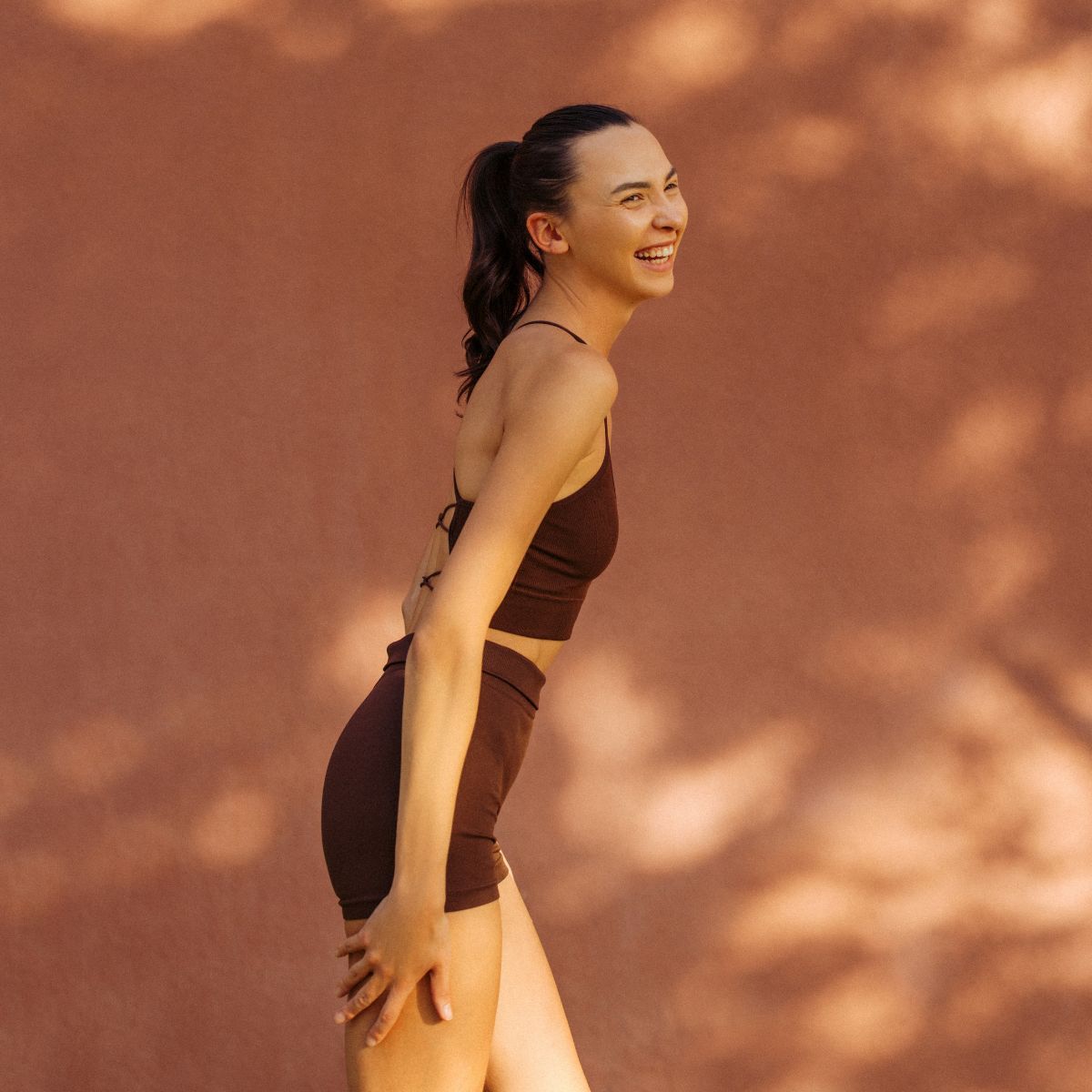 A woman stood against a terracotta wall in gym kit during her September reset