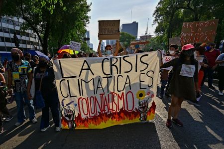 Demonstrators hold sign reading ‘the climate crisis is colonialism’ at Fridays for Future protest in Mexico City