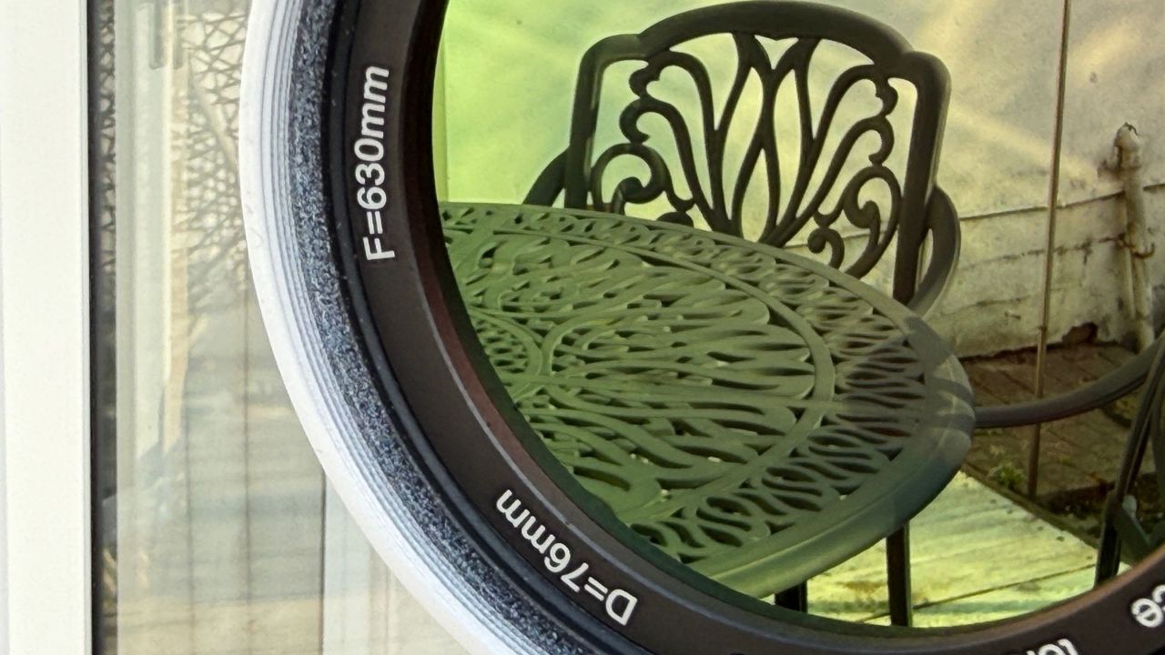 Close-up reflection of a table and chair in the 76mm aperture of the Sky-Watcher Heliostar 76mm H-alpha solar telescope.