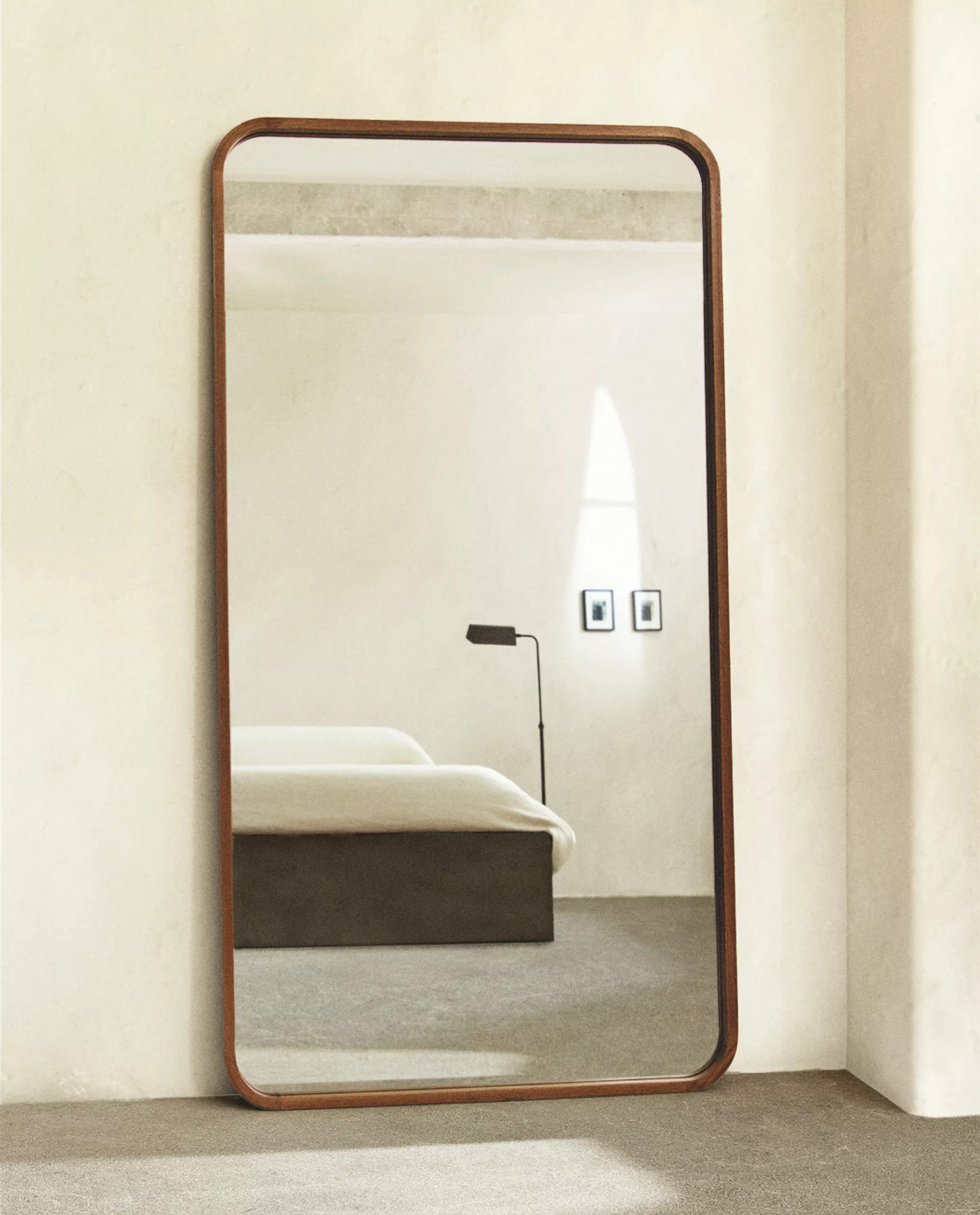 Rounded wood mirror in a bedroom