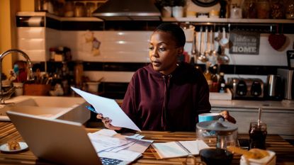 Women sitting at a table with an open laptop reviewing bills