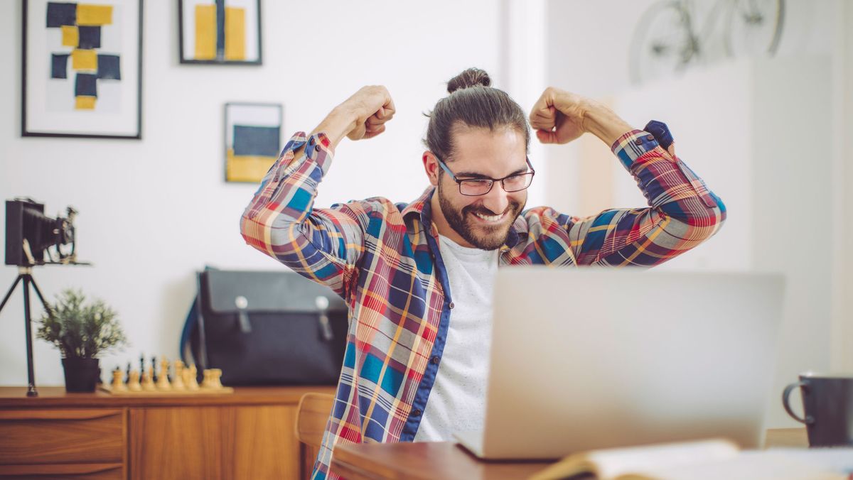 Man celebrating at computer