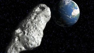 A gray rocky asteroid heads back toward Earth in the darkness of space