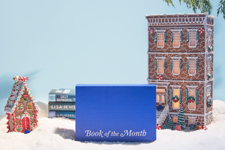 A blue Book of the Month box in front of a winter scene