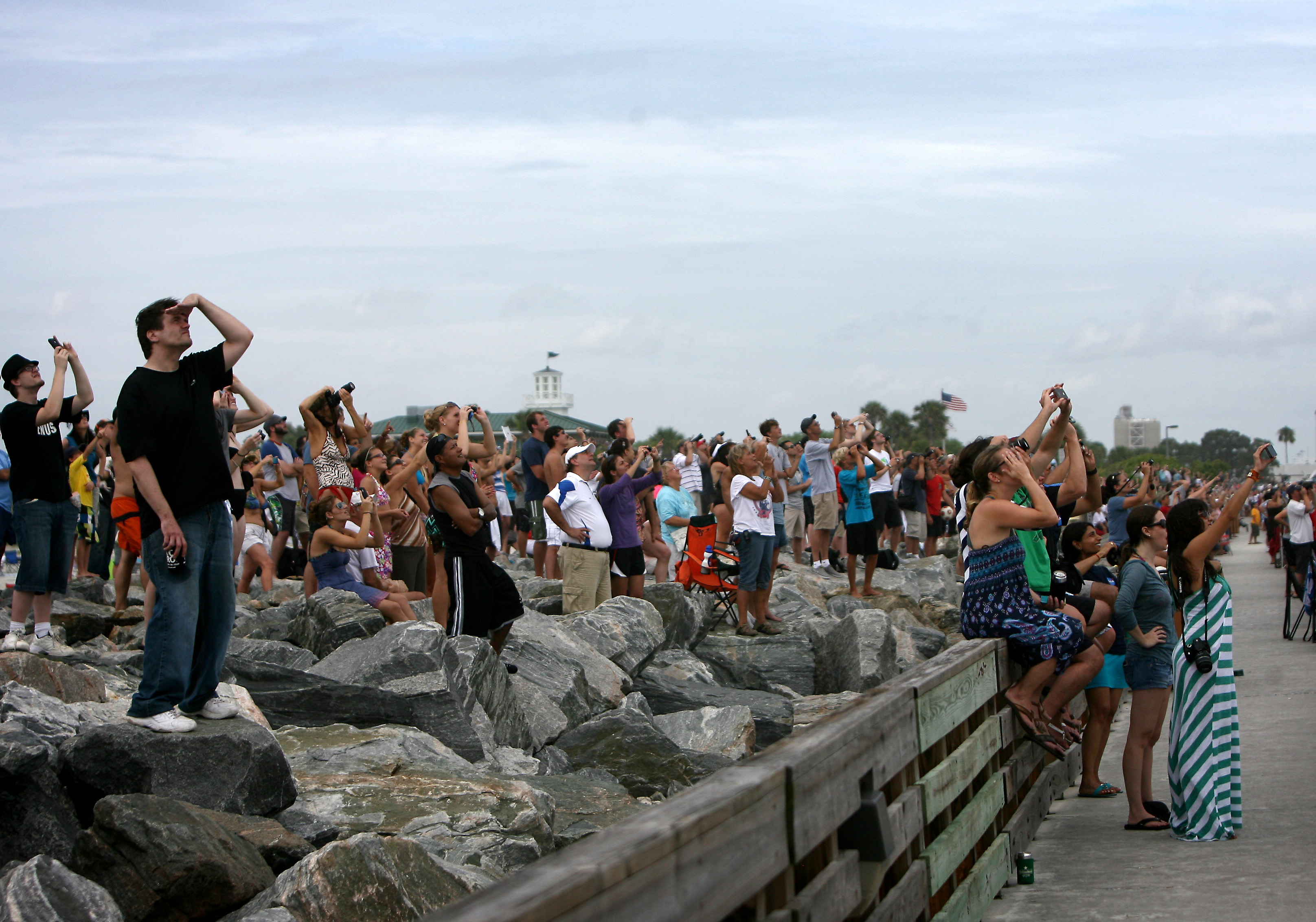 Een grote menigte mensen kijkt vanaf Jetty Park in Cape Canaveral toe terwijl de spaceshuttle Atlantis wordt gelanceerd, vrijdag 8 juli 2011.