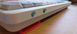 A white NuPhy Air75 V2 keyboard on a wooden desk