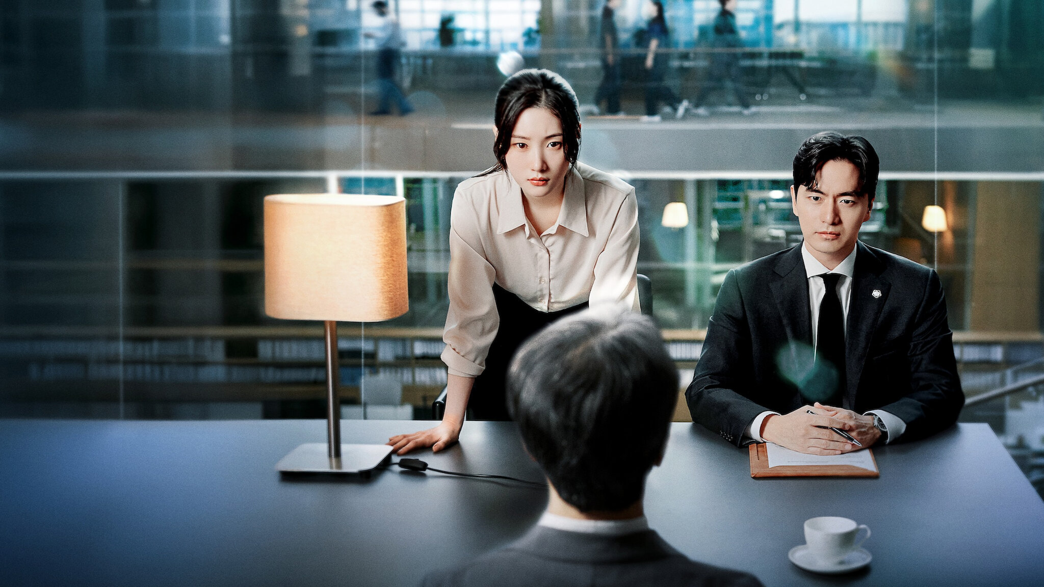 Two lawyers (played by Jung Chae-yeon and Lee Jin-wook) face a man as they sit at a conference table in a glass-walled office, in the K-drama &#039;Beyond the Bar.&#039;