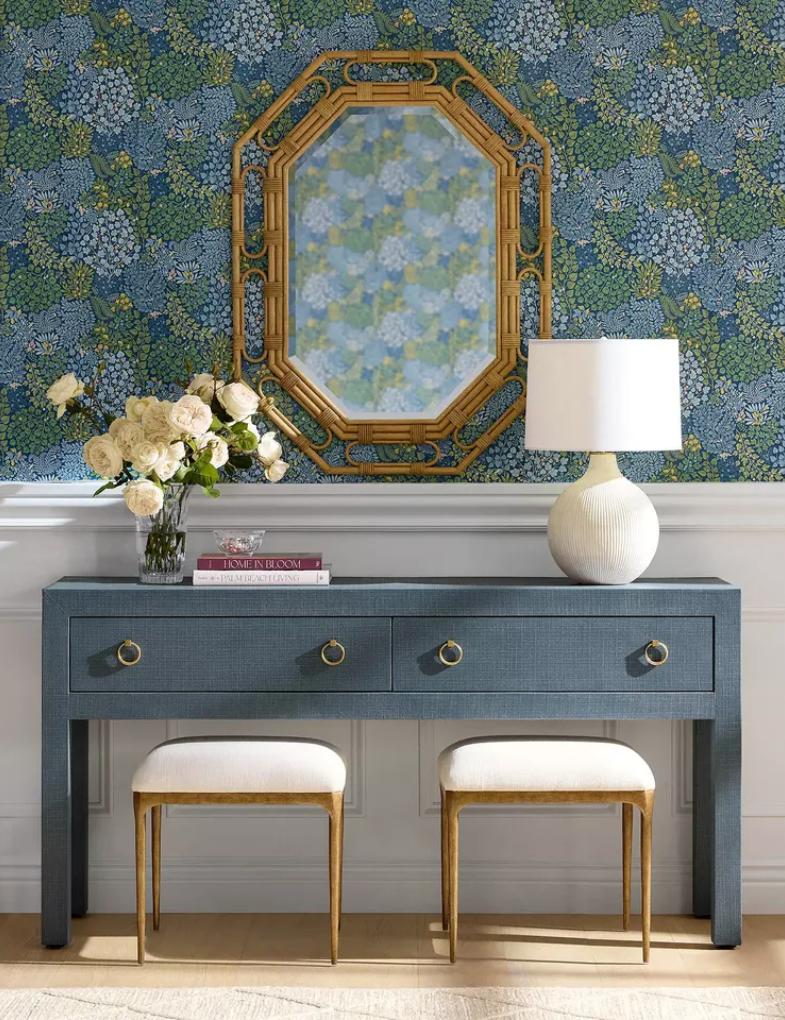 Bright blue-and-white vanity area featuring patterned wallpaper and a geometric rattan accent mirror