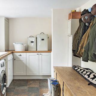 laundry room with white cabinets and baskets