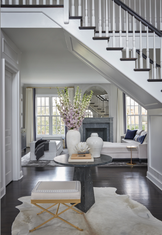 Monochrome entryway with a cowhide rug and white furnishings