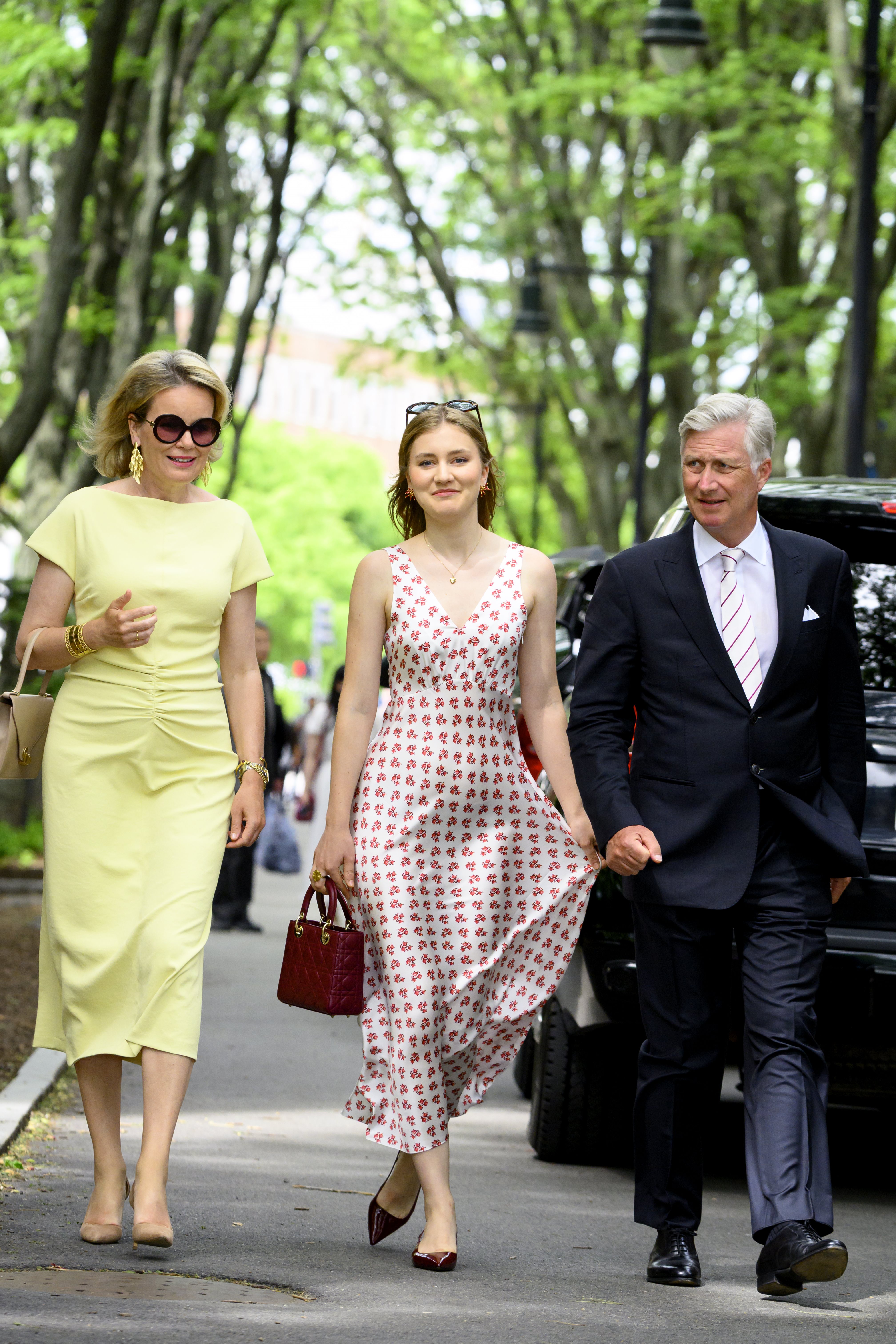 Queen Mathilde, Princess Elisabeth and King Philippe walking down a road