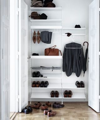 String metal string system in white with white wall panels, shoes and clothes hanging, parquet flooring