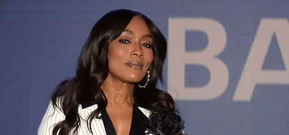 Angela Bassett wearing a white pinstripe jacket and black shirt
