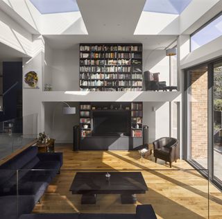 open plan modern living room extension with large bookcase and reading mezzanine