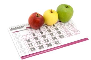 Three apples sit lined up on a calendar.