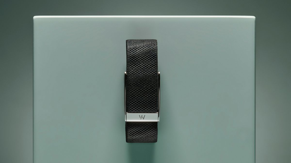 The black fabric Whoop band with silver clasp pinned to a turquoise box