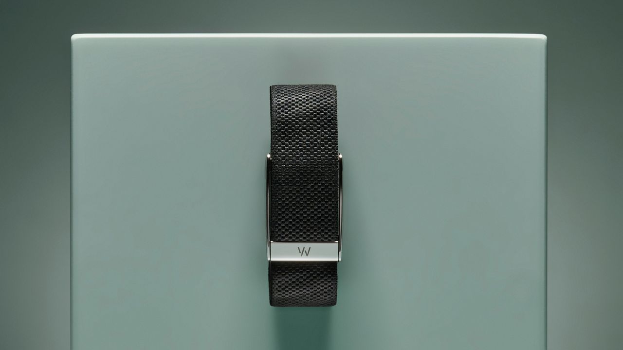 The black fabric Whoop band with silver clasp pinned to a turquoise box