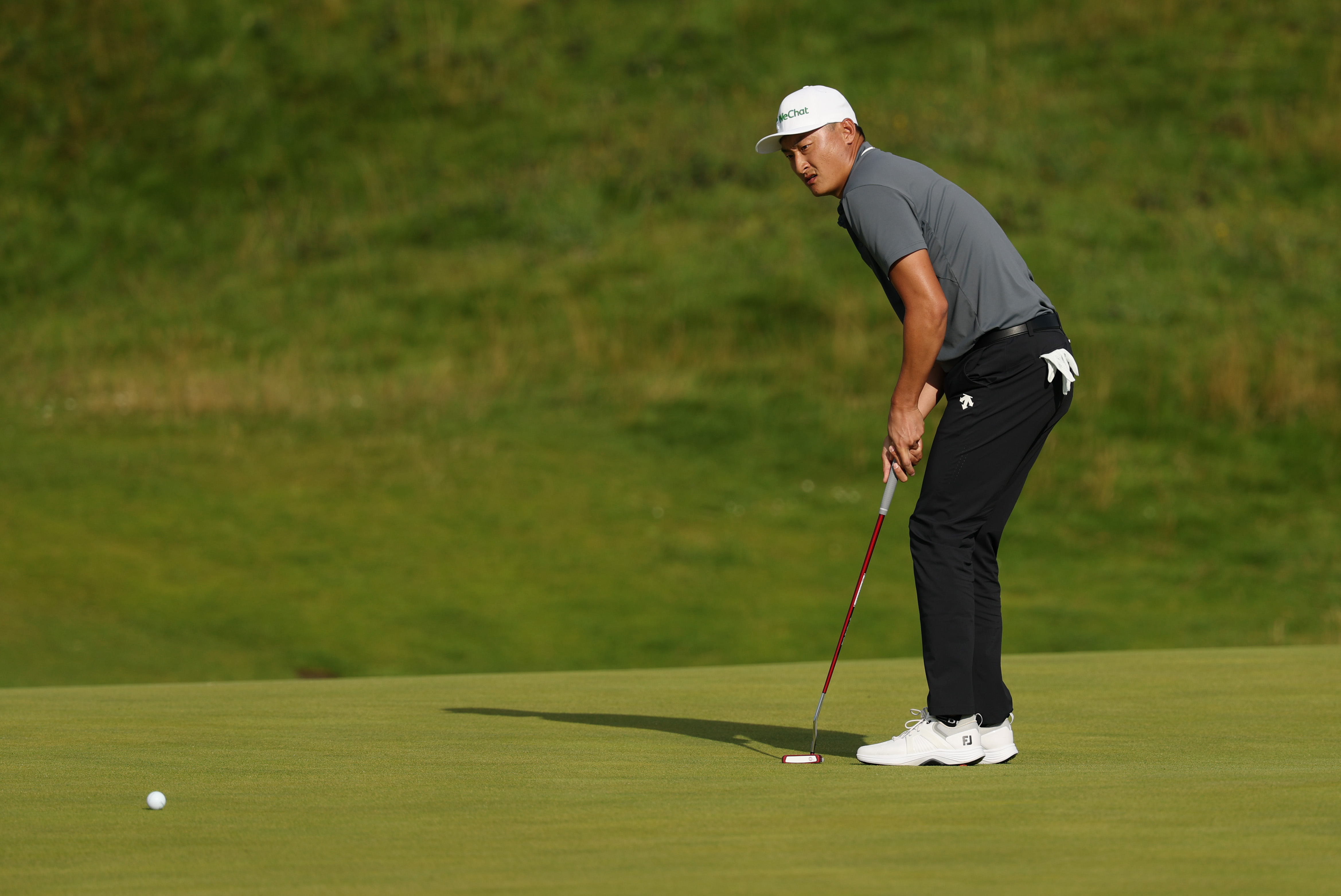 Haotong Li hits a putt