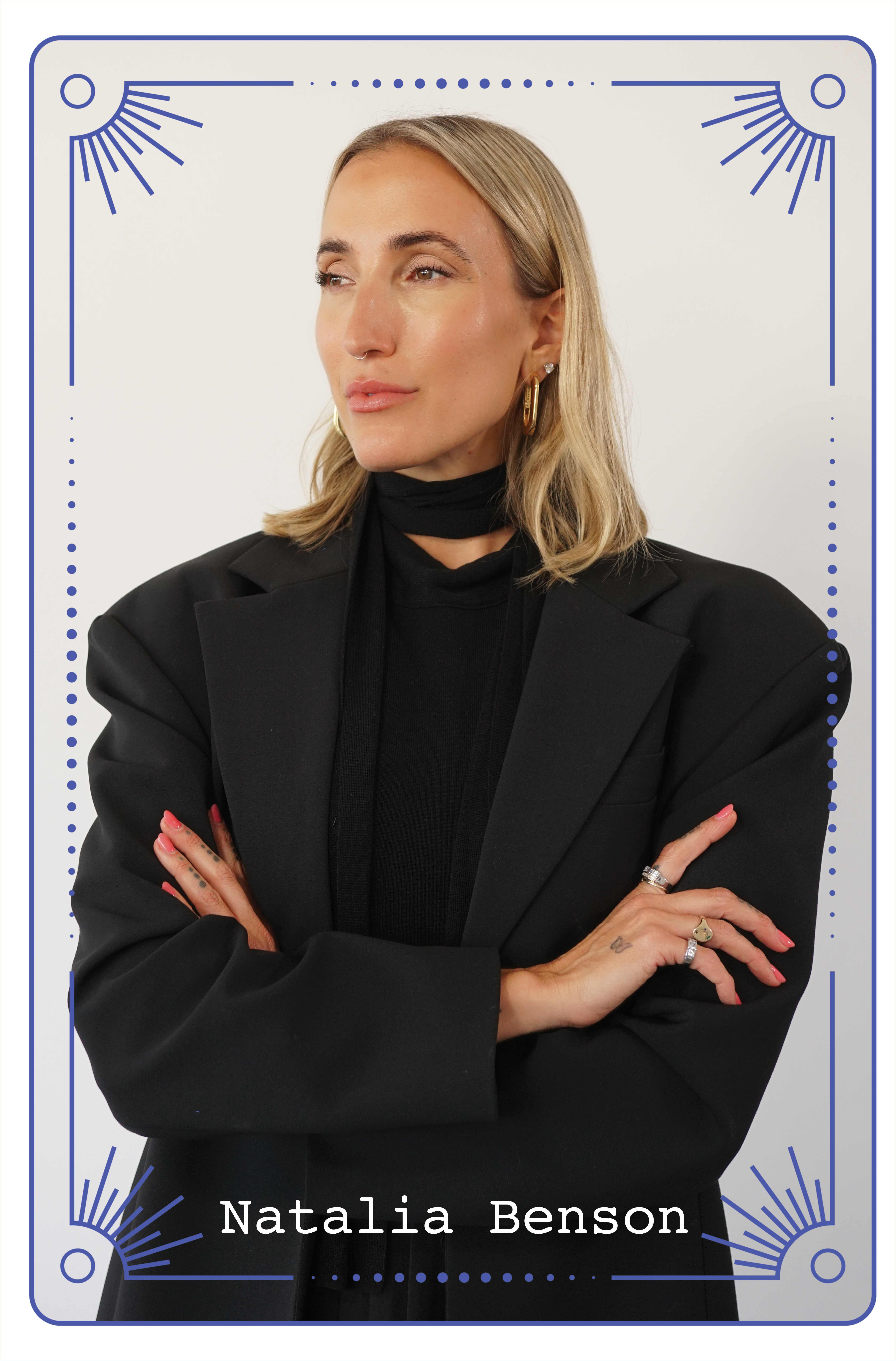 Natalia Benson poses against a light background wearing a structured black blazer and turtleneck.
