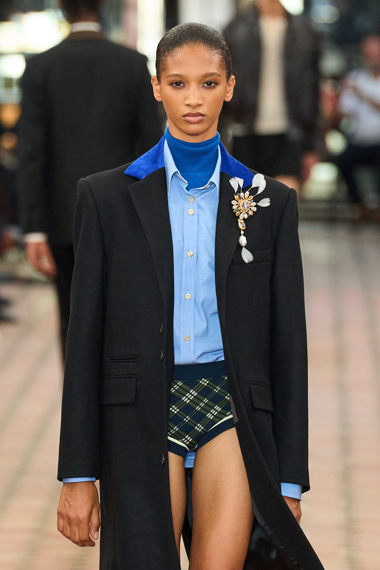 A model wearing a Wales Bonner brooch.
