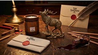 A collection of Traitors merchandise and Highland themed desk accessories on a desk in a dark, gothic home office