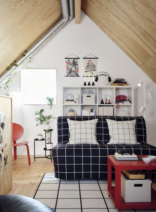 teen bedroom/playroom with sofa, shelving, chair, red coffee table, red chair, floor lamp, shelving unit